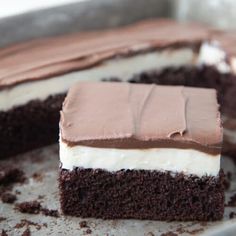 a piece of cake with chocolate frosting and white icing sitting on a pan