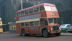 an old double decker bus is driving down the street in front of other cars and buses