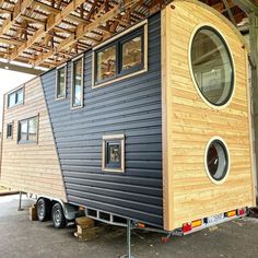 a tiny house on wheels is being built in the back of a trailer with windows