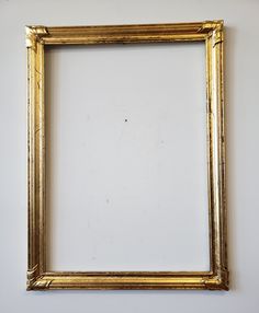 an empty gold frame hanging on the wall