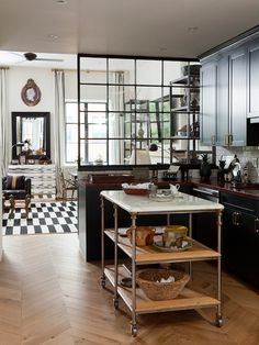 a kitchen with black and white checkered flooring, stainless steel appliances and cabinets