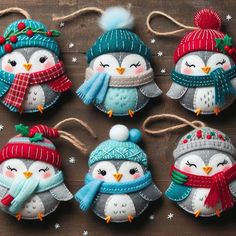 christmas ornaments with owls wearing hats and scarves hanging from string on wooden table top