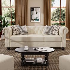 a living room filled with white furniture and large window covered in brown drapes on the windowsill