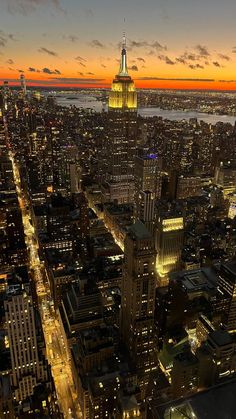 an aerial view of new york city at night with the empire building in the foreground