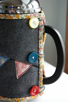 a close up of a coffee mug with buttons on it