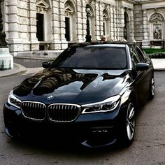 a black car parked in front of a large building