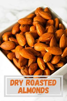 roasted almonds in a square white bowl with the words dry roasted almonds