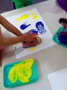 two children are playing with their handprints on the paper and plastic trays