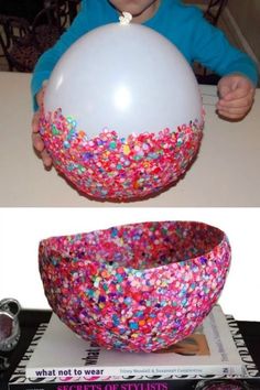 a young boy holding a balloon in front of a bowl filled with sprinkles