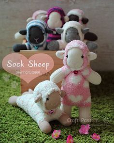 several stuffed animals sitting in the grass with a sign that says sock sheep above them