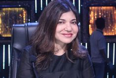 a woman sitting in front of a black chair