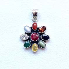 Genuine 925 Sterling Silver Navratan Pandent  Gemstone - Ruby , Emerald , Blue Sapphire, Yellow Sapphire, Hessonite, Cats Eye, Coral, Pearl, Cubic Zircona.  Stones setted - 9 pieces QTY - 1 piece in this listing. The navratna or nine gems influencing the nine planets are:  Ruby  =  Sun ,  Pearl = Moon, Red Coral = Mars, Emerald = Mercury,  Yellow Sapphire = Jupiter, zircon = Venus, Blue Sapphire = Saturn,  Hessonite = Rahu , Cat''s Eye = Ketu . Multicolor Stone Round Pendant Jewelry, Sterling Silver Multi-stone Round Pendant, Multicolor Round Pendant Jewelry With Stones, Sterling Silver Multi-stone Round Pendant Jewelry, Multicolor Gemstone Oval Pendant Jewelry, Spiritual Silver Gemstone With Oval Pendant, Spiritual Silver Oval Pendant Gemstone, Multicolor Oval Pendant Gemstone Jewelry, Spiritual Sterling Silver Gemstone Pendant