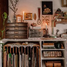 an old fashioned desk with many drawers and pictures on the wall above it, along with other items