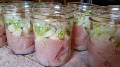 several jars filled with food sitting on top of a table next to a towel covered floor