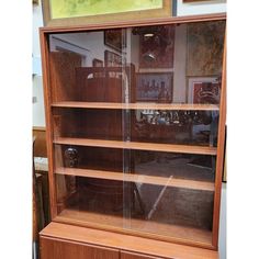 a wooden bookcase with glass doors and shelves