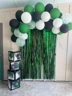 green and white balloons are hanging from the ceiling