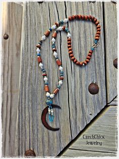 A rustic copper crescent moon pendant is the focus of this colorful boho beaded necklace.  Featuring  brown wood beads, white Magnesite, blue porcelain and galvanized silver seed beads strung on strong  Irish waxed linen.  Closure is a silver toggle clasp. Designed for a western/boho look; great gift for the gal who loves to wear unique jewelry.  It's truly a one-of-a-kind necklace! Necklace is 25 1/2" long with a silver toggle clasp.   If length or clasp is an issue I am happy to alter my jewelry to please the customer! I ship my jewelry in decorative boxes that are ready for gift giving.  Shipments are usually mailed 24-48 hours from when order is received, unless it's made to order. You will always be provided with a tracking number upon order receipt. Express shipping is also available Stretch Beaded Bracelets Diy, Cowgirl Accessories, Crescent Moon Pendant, Crescent Moon Necklace, Cow Girl, Beaded Bracelets Diy, Bead Stringing, Colorful Boho, Moon Pendant