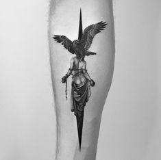 a black and white photo of a woman with an eagle tattoo on her leg,