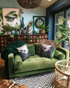 a living room filled with green furniture and lots of plants on top of the couch