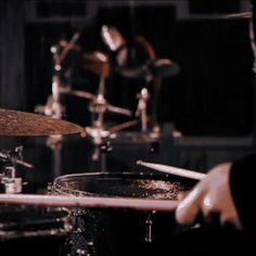 a person is playing drums in a dark room