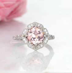 Beautiful Vintage Inspired Morganite Ring ►Made of solid sterling silver with a rhodium finish (925) ►Accented with simulated diamonds (CZ) Center Stone: Morganite Stone Cut: Cushion Color: Peachy- Pink Gem size: 7.0 mm Carat Weight: 1.28 ct. Stone Creation: Simulated ►Matching band can be purchased here: https://www.etsy.com/listing/815340258/chevron-wedding-band-sterling-silver?ga_search_query=curved&ref=shop_items_search_11&frs=1 ✓ 100% Nickel-Free ✓ Hypoallergenic ✓ Comfort Fit ✓ Fre Anniversary Rings With Morganite And Prong Setting, Morganite Rings With Prong Setting For Anniversary, Classic Gemstone Flower Ring For Wedding, Classic Wedding Flower Ring With Halo Setting, Heirloom Flower Ring With Center Stone For Anniversary, Classic Wedding Flower Ring With Gemstone, Morganite Diamond Ring With Accent Stones For Anniversary, Heirloom Morganite Diamond Ring For Anniversary, Classic Halo Topaz Ring For Wedding