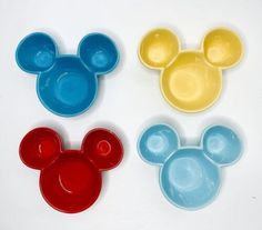 three mickey mouse plates are shown on a white surface