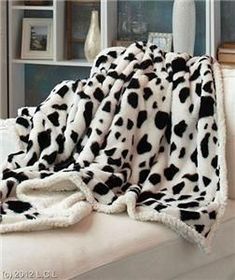 a white and black blanket sitting on top of a couch next to a window sill