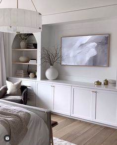 a bedroom with white furniture and a large painting hanging on the wall above the bed