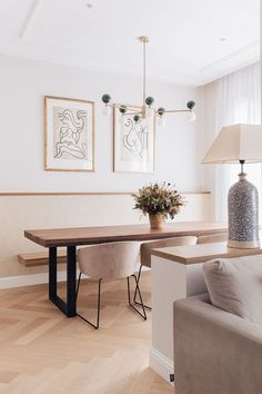 a living room with a couch, table and two pictures on the wall above it