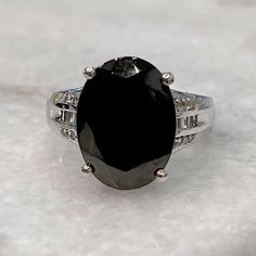 Large Oval Faceted Shungite Stone Set In Stunningly Detailed Platinum Over Sterling Silver Ring. Three Rows Of White Topaz (2 Rows Of Round Stones; 1 Round Of Rectangular Baguettes) Shungite Is Anecdotally Believed To Have Healing Benefits And Protects And Neutralizes Effects From Harmful Electromagnetic Fields Marked 925 Size 8 Black Oval Gemstone Accent Jewelry, Black Oval Jewelry With Gemstone Accents, Shungite Stones, White Topaz, Ring Box, Stone Settings, Womens Jewelry Rings, Sterling Silver Ring, Black Silver