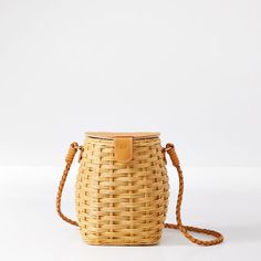 Lovely and laid back, inspired by nostolgic fishing basket desigm, the artfully woven Nantucket Wicker Crossbody has an exquisite braided leather accent that displays its skillful handcraftsmanship. With a unique semi-circle bucket style and compact size, it features a striped cotton lining and magnetic closure. A foil debossed monogram on the leather top adds a personal touch. About the artisan: This item is handmade by artisans in the Philippines. A woman-owned and operated organization, they are a member of the Nest Artisan Guild that is committed to improving women's wellbeing beyond factories and preserving important cultural traditions around the world.  5"w x 4"d x 7"h  Strap: 21"  Woven rattan wicker, cotton lining, leather.  Clean with a dry cloth.  Handmade in the Philippines.  M Summer Bucket Shoulder Bag With Intrecciato Weave, Casual Bucket Bag With Intrecciato Weave, Everyday Braided Bucket Bag, Braided Natural Bucket Bag For Everyday Use, Natural Braided Bucket Bag For Everyday Use, Natural Braided Everyday Bucket Bag, Straw Bucket Bag With Intrecciato Weave, Casual Bucket Straw Bag With Intrecciato Weave, Summer Bucket Bag With Intrecciato Weave