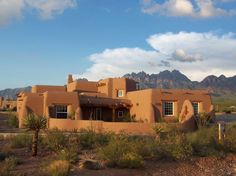 an adobe style house with mountains in the background