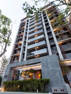 an apartment building with many windows and plants growing on the outside, in front of it