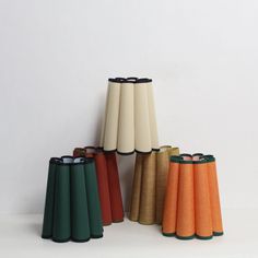 several different colored vases sitting next to each other on a white surface with no one around them