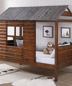 a wooden cabin bed with a teddy bear in the corner