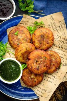 some food is on a blue plate with sauces and parsley next to it