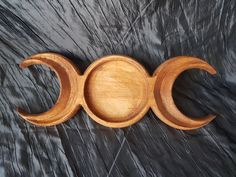 three wooden bowls sitting on top of a black cloth