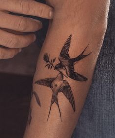 a person with a bird tattoo on their arm