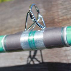 a close up of a bicycle handlebar on a wooden bench with green and gray stripes