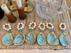 five pieces of jewelry sitting on top of a table next to candles and other items