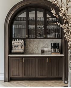 an arched glass cabinet with wine glasses on it