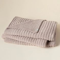 three towels folded on top of each other in front of a light colored background,