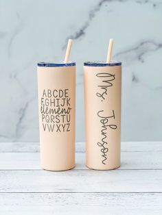 two tumblers with writing on them sitting next to each other