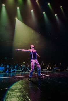 a man standing on top of a stage in front of a crowd