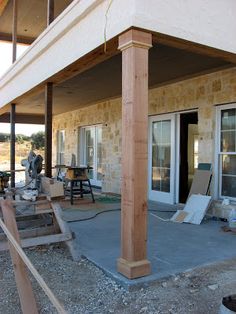 an outside patio with steps leading up to the front door and covered porch area next to it