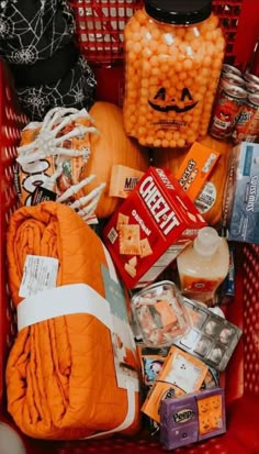 a shopping cart filled with candy and other items for halloween season, including an orange pumpkin