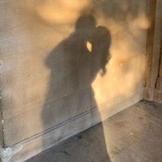 the shadow of a person standing in front of a wall