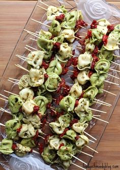 several skewered food items are on a clear platter with toothpicks and ketchup