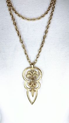 "Vintage Trifari gold double chain pendant necklace Measurements... -length: 16\" Features... -chunky gold toned chain -chains are attached with one clasp in the back -swivel hanging pendant Condition: -excellent vintage condition 1I3231*" Gold-tone Brass Pendant Chain Necklace, Gold Chain Brass Pendant Necklace, Gold Chain Pendant Necklace In Brass, Gold-tone Brass Long Chain Necklace, Gold-tone Long Brass Chain Necklace, Long Gold-tone Brass Chain Necklace, Vintage Gold-tone Metal Chain Necklace, Antique Gold Brass Chain Necklace With Adjustable Chain, Vintage Double Chain Metal Necklace