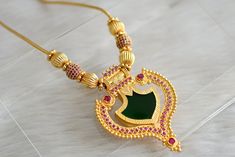 Gold tone Kerala style Pink-green palakka kodi necklace. 24 cm Length. Kodi Necklace, Green Temple Jewelry Necklace For Festivals, Green Chandbali Temple Necklace As Gift, Green Temple Necklace With Tilla As A Gift, Green Temple Necklace With Tilla For Gift, Green Emerald Necklace In Temple Jewelry Style For Festivals, Green Emerald Necklace For Festivals In Temple Jewelry Style, Green Temple Jewelry Necklaces For Festive Occasions, Green Temple Necklace With Latkans For Diwali